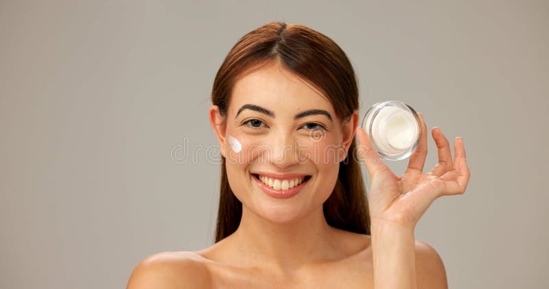 Porträt Lächeln und Frau mit Creme Skincare und Dermatologie auf grauem Studio Hintergrund. Persönlichkeitsmodell und Mädchen mit lizenzfreie stockbilder