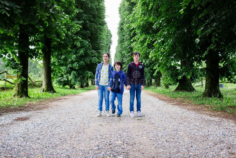 Porträt mit drei Brüdern in einer Baum gezeichneten Allee lizenzfreie stockfotos Porträt mit drei Brüdern in einer Baum gezeichneten Allee lizenzfreie stockfotos