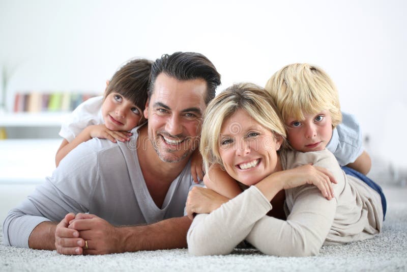 Porträt von den Eltern und von Kindern, die auf dem Boden liegen lizenzfreies stockbild Porträt von den Eltern und von Kindern, die auf dem Boden liegen lizenzfreies stockbild