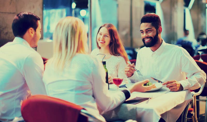 Porträt von den glücklichen und lächelnden Erwachsenen, die zu Abend essen lizenzfreie stockfotografie Porträt von den glücklichen und lächelnden Erwachsenen, die zu Abend essen lizenzfreie stockfotografie
