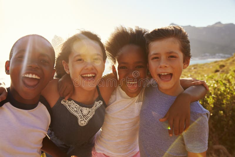 Porträt von den lächelnden Kindern, die auf Klippen durch Meer stehen lizenzfreie stockfotografie Porträt von den lächelnden Kindern, die auf Klippen durch Meer stehen lizenzfreie stockfotografie