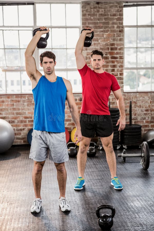 Porträt von den muskulösen Männern, die kettlebell anheben lizenzfreie stockfotos Porträt von den muskulösen Männern, die kettlebell anheben lizenzfreie stockfotos