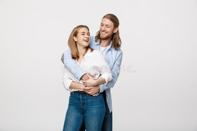 Porträt von den netten jungen Paaren, die auf lokalisiertem weißem Hintergrund stehen und sich umarmen stockfotos Porträt von den netten jungen Paaren, die auf lokalisiertem weißem Hintergrund stehen und sich umarmen stockfotos