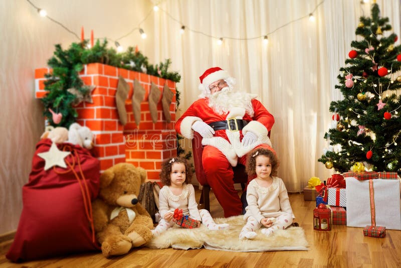 Porträt von Santa Claus- und Mädchendoppelbabys, Kind im Raum b stockbild Porträt von Santa Claus- und Mädchendoppelbabys, Kind im Raum b stockbild