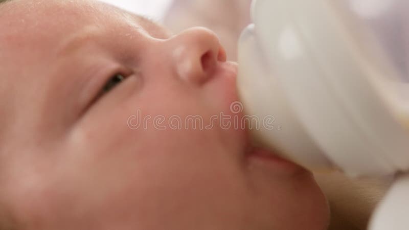 Porträtkleinkind, das verdünntes Milchpulver trinkt. trinkende Muttermilch des Kaukasus Neugeborenen vom kleinen Plastikbaby