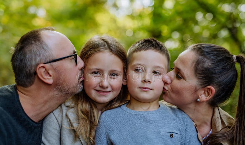 Porträtt av en lyckad familj med barn i en skog. arkivbilder
