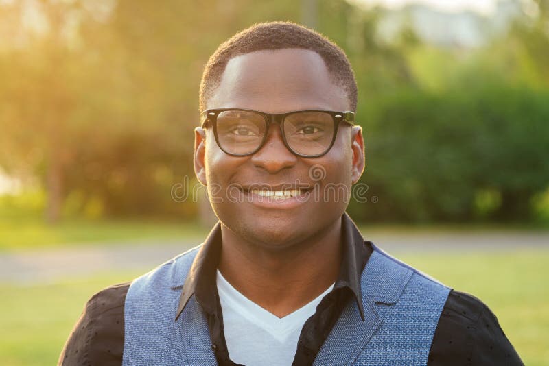 Porträtt av en ung och stilfull modell av afro-amerikan man i en stilfull blåkostur på glasögonen, i en fotografering för bildbyråer Porträtt av en ung och stilfull modell av afro-amerikan man i en stilfull blåkostur på glasögonen, i en fotografering för bildbyråer