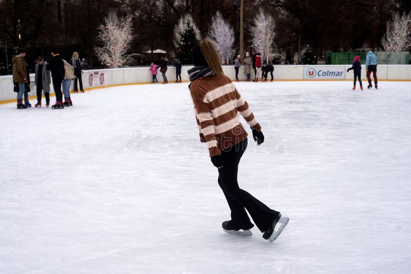 Colmar - France - 9 december 2022 - portrait of girl with black leggings slipping on an ice christmas rink. Colmar - France - 9 december 2022 - portrait of girl with black leggings slipping on an ice christmas rink