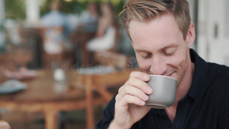 Porträtt av stilig man som dricker varm dryck från kopp i kafé och leende stock video