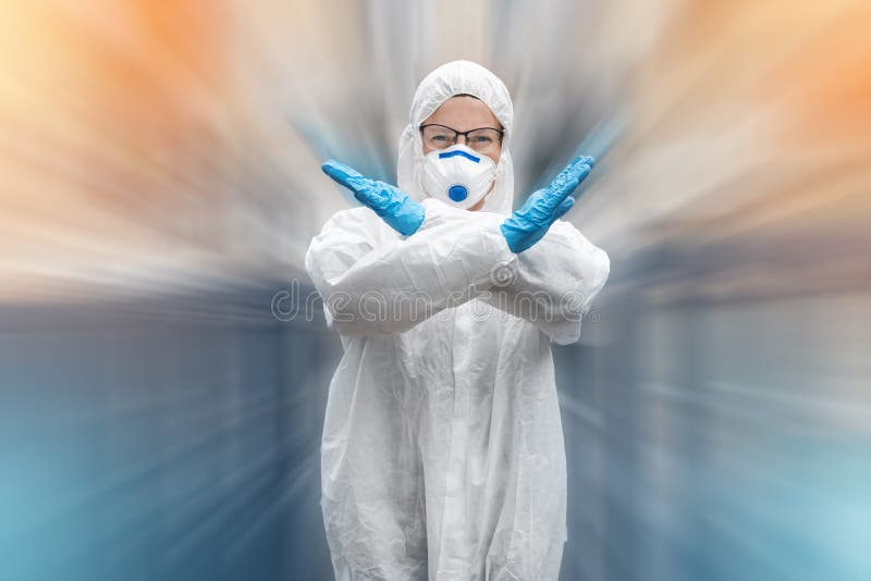 Portrait of tired exhausted female doctor, scientist or nurse wearing face mask and biological hazmat ppe suit showing crossed arms stop no gesture outdoor. Coronavirus covid-19 outbreak danger. Portrait of tired exhausted female doctor, scientist or nurse wearing face mask and biological hazmat ppe suit showing crossed arms stop no gesture outdoor. Coronavirus covid-19 outbreak danger