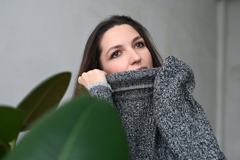 Porträtt av vacker kvinna med slutna ögon. nära porträtt av en underbar, ung brunett i sötare på grå bakgrund arkivbilder