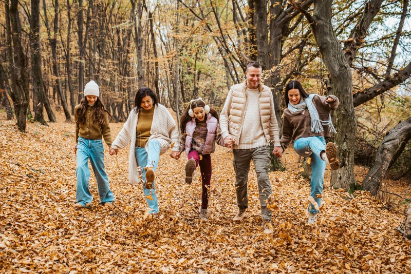 Porträtt för flera generationer. mor- och farföräldrar och döttrar på promenad i skogen. royaltyfri bild