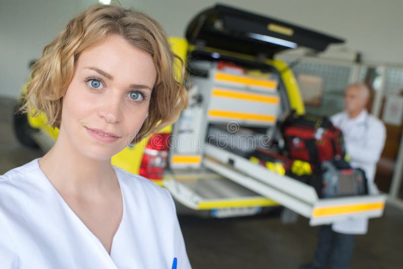 Porträtärztin, die im vorderen Krankenwagen steht lizenzfreies stockfoto Porträtärztin, die im vorderen Krankenwagen steht lizenzfreies stockfoto