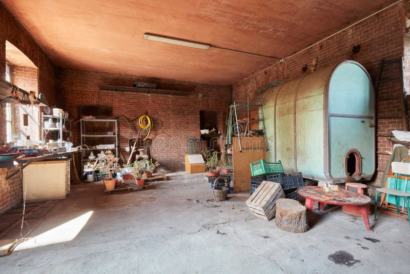 Porão desarrumado com as paredes do tambor grande e de tijolos vermelhos na casa velha foto de stock Porão desarrumado com as paredes do tambor grande e de tijolos vermelhos na casa velha foto de stock