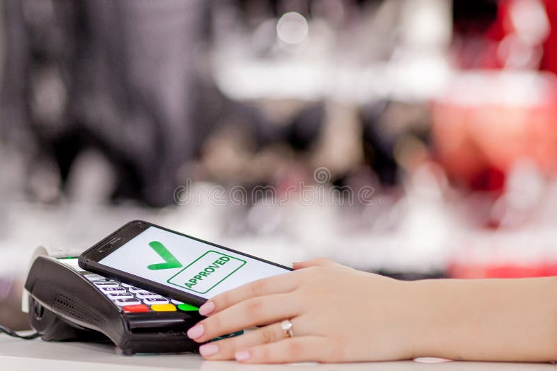 POS terminal, Payment Machine with mobile phone on store background. Contactless payment with NFC technology