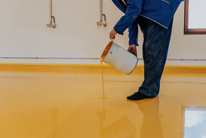 Worker, coating floor with self-leveling epoxy resin in industrial workshop. Worker, coating floor with self-leveling epoxy resin in industrial workshop