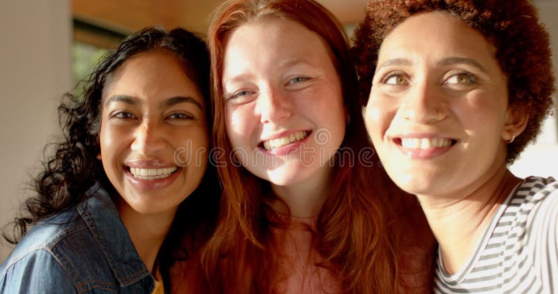 Posando y sonriendo a diversas amigas disfrutando del tiempo juntos en el interior metrajes