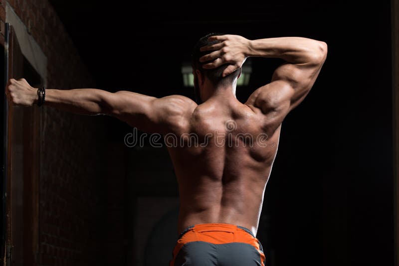 Pose modelo muscular de Flexing Back Muscles imagem de stock royalty free