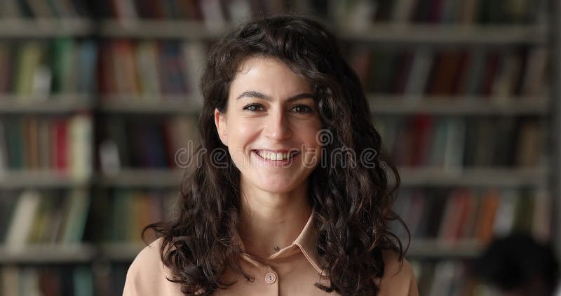 Pose souriante d'une adolescente dans une bibliothèque pose à la caméra banque de vidéos