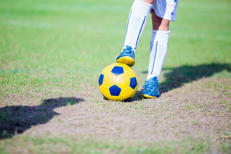 O Menino Do Jogador De Futebol Está Pisando Na Bola Na Sala Foto