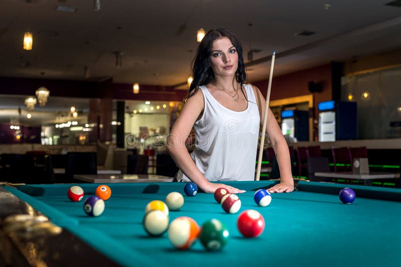 Mulher bonita no bar ao lado da mesa de sinuca, gente jogando