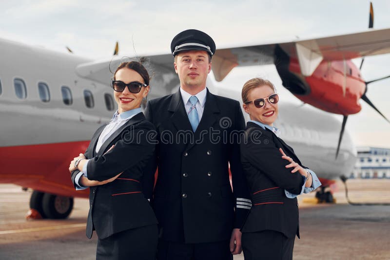 Posing for a Camera. Crew of Airport and Plane Workers in Formal Clothes Standing Outdoors