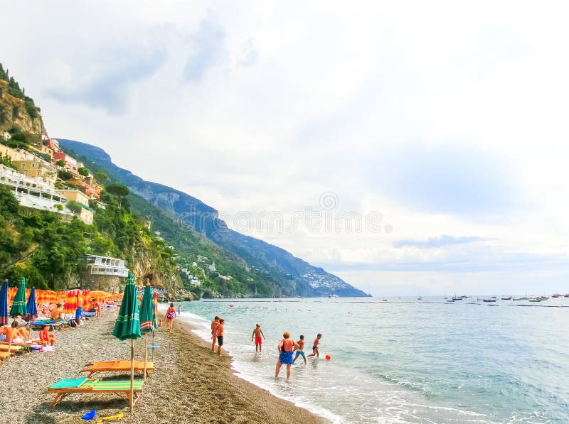 Positano, Italy - September 11, 2015: The people resting at the beach at Positano at Amalfi Coast on September 11, 2015. Positano, Italy - September 11, 2015: The people resting at the beach at Positano at Amalfi Coast on September 11, 2015