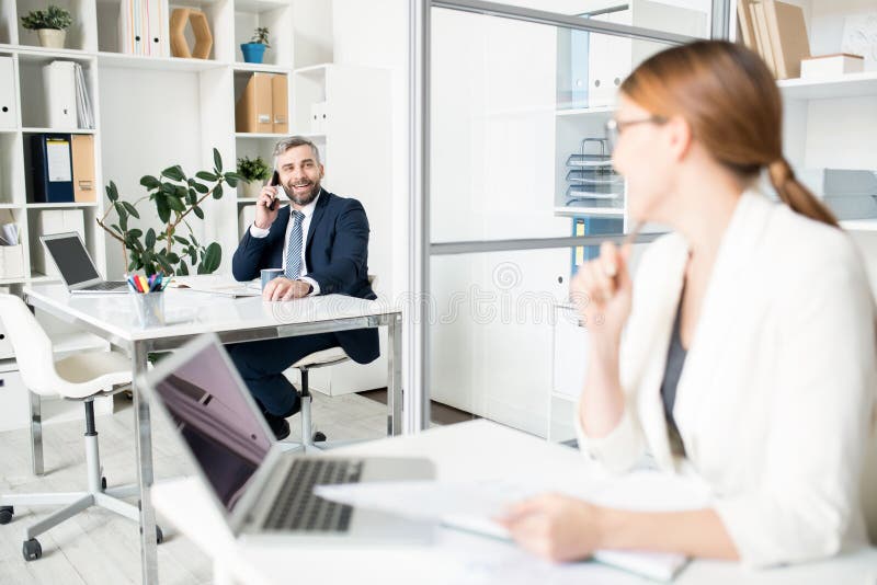 Positieve mannelijke manager die met collega overleggen terwijl langs het spreken royalty-vrije stock fotografie Positieve mannelijke manager die met collega overleggen terwijl langs het spreken royalty-vrije stock fotografie