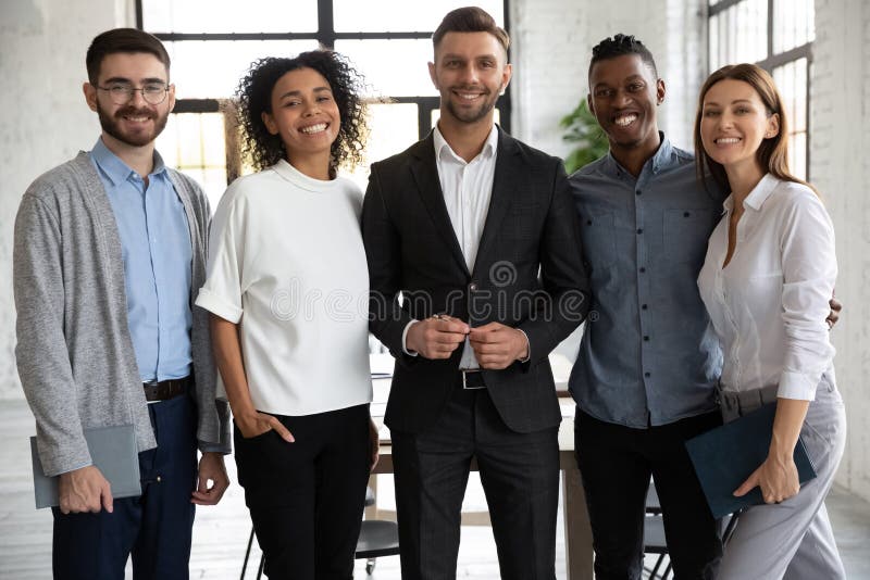 Position dans l'équipe variée de sourire de ligne à regarder la caméra. photo stock