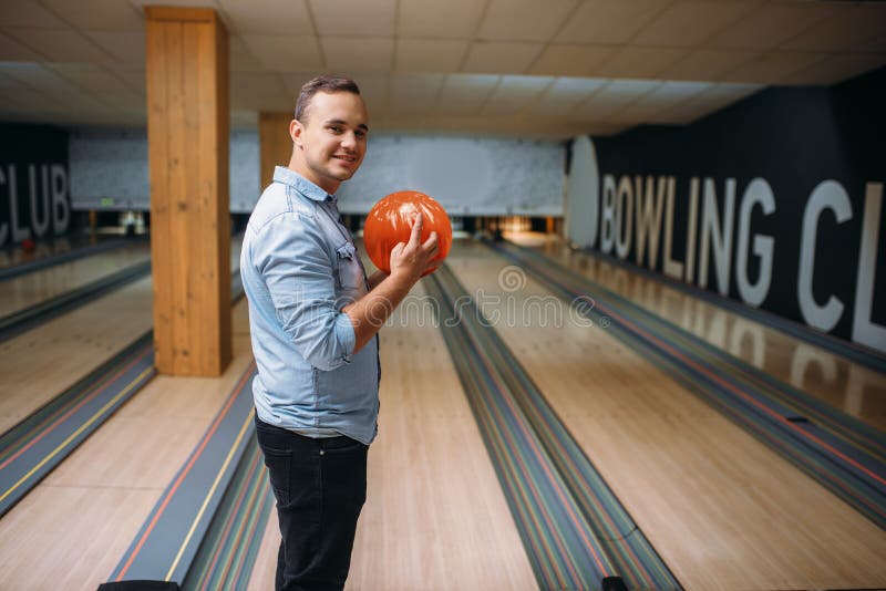 Position masculine de lanceur sur la ruelle et poses avec la boule image stock Position masculine de lanceur sur la ruelle et poses avec la boule image stock