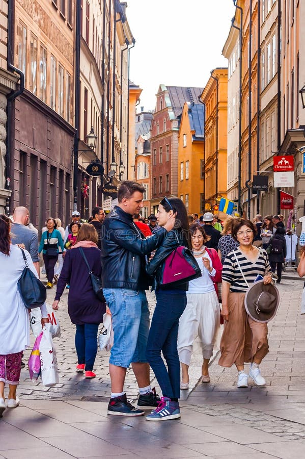 Position romantique de couples au centre de la rue médiévale serrée dans Gamla Stan, vieille ville de Stockholm photographie stock Position romantique de couples au centre de la rue médiévale serrée dans Gamla Stan, vieille ville de Stockholm photographie stock