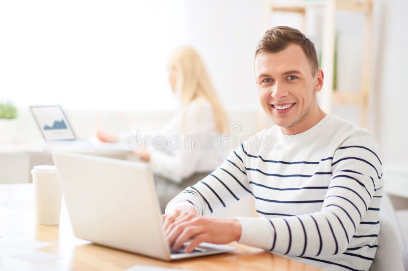 Positiv grabb som arbetar på bärbara datorn royaltyfria bilder Positiv grabb som arbetar på bärbara datorn royaltyfria bilder