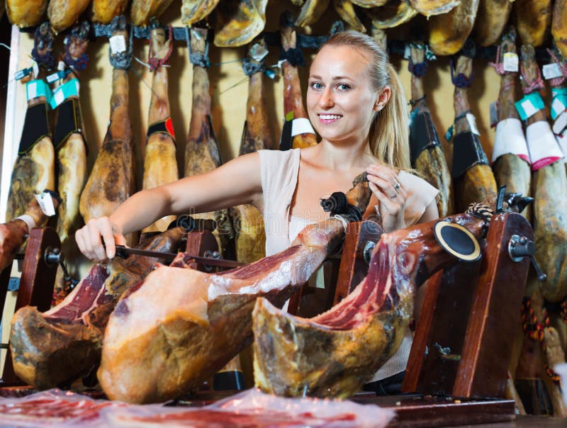 Positiv kvinnlig kund som väljer iberian skinka royaltyfri fotografi Positiv kvinnlig kund som väljer iberian skinka royaltyfri fotografi