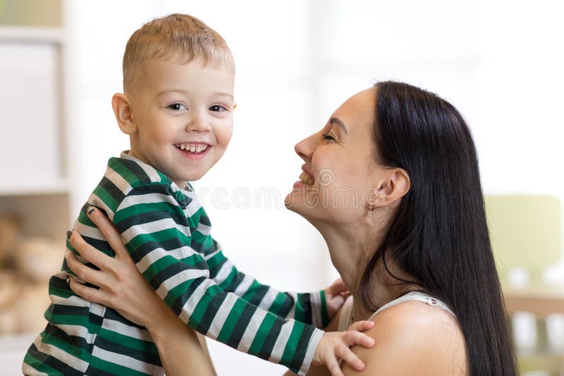 Positiv unge och mamma Barnmoderlekar med hennes lilla son royaltyfria bilder Positiv unge och mamma Barnmoderlekar med hennes lilla son royaltyfria bilder