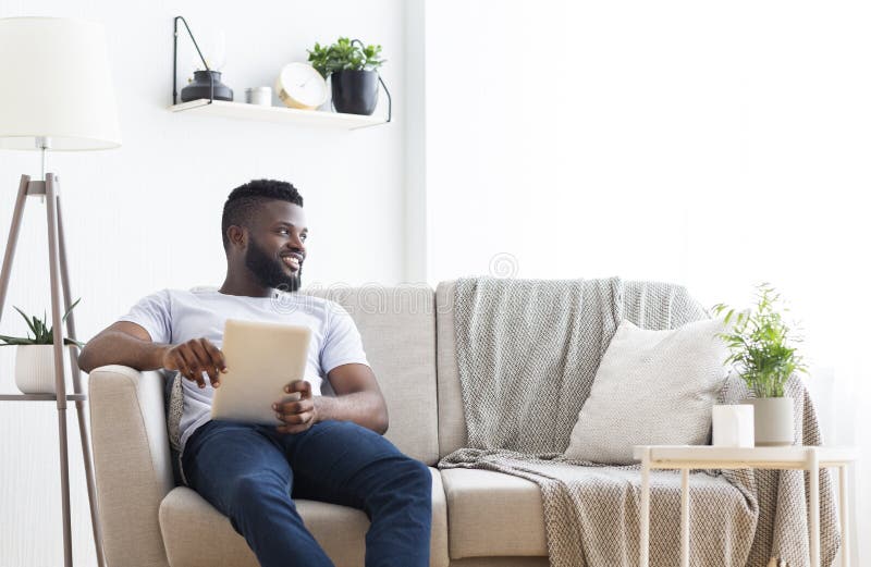 Positive african american with digital tablet looking aside royalty free stock photos Positive african american with digital tablet looking aside royalty free stock photos