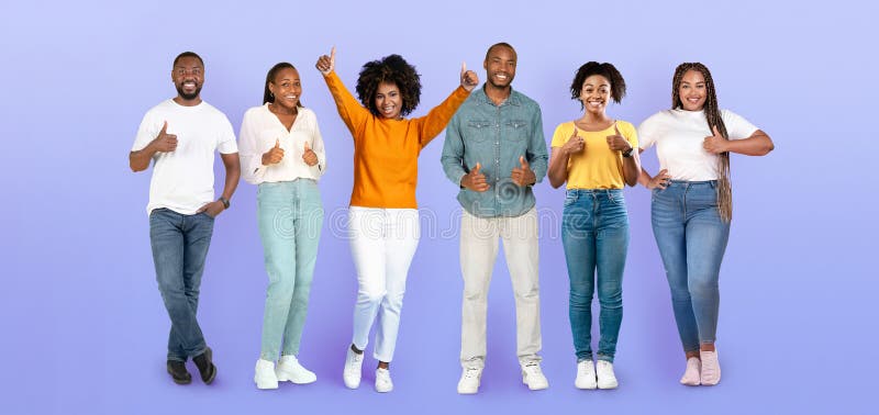 Positive african american young women, men in casual show thumbs up, enjoy lifestyle royalty free stock photo