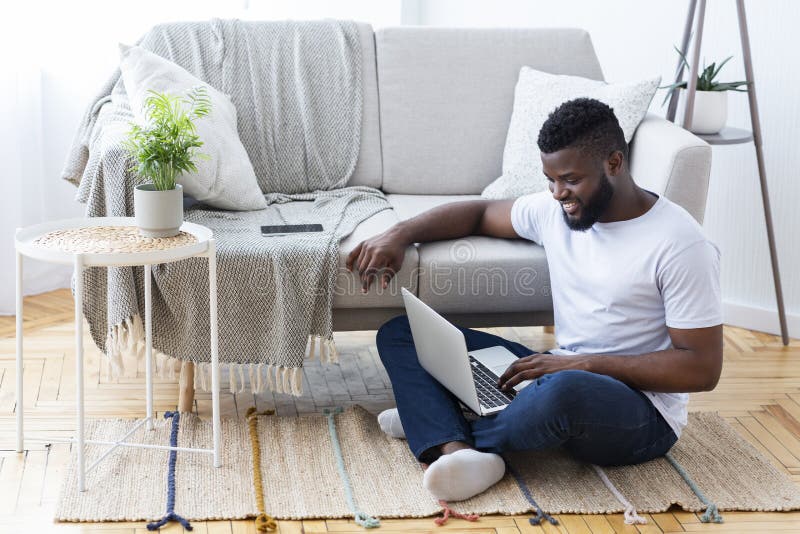 Positive african man surfing internet on laptop stock photography Positive african man surfing internet on laptop stock photography