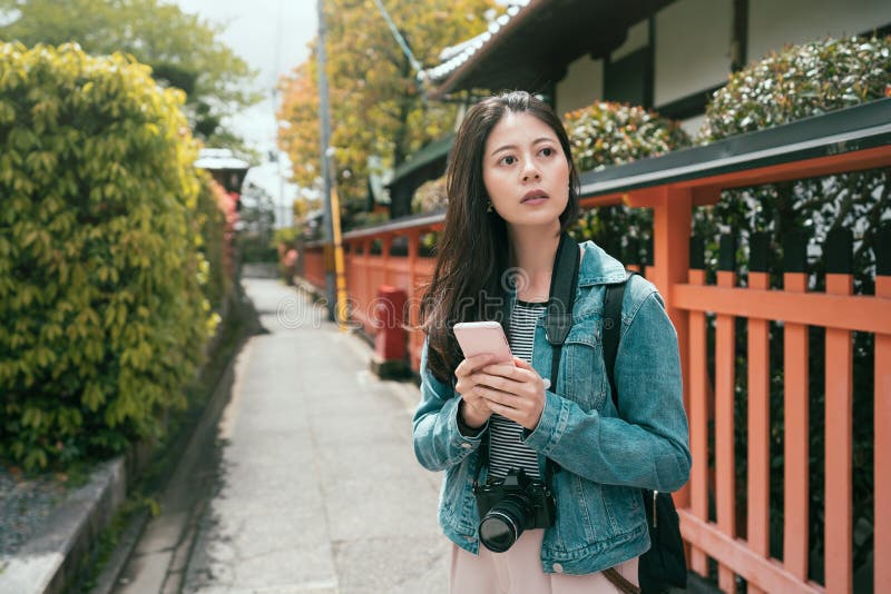 Positive asian girl traveler using smartphone royalty free stock image