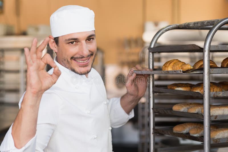 Positive baker checking freshly baked bread stock photography Positive baker checking freshly baked bread stock photography