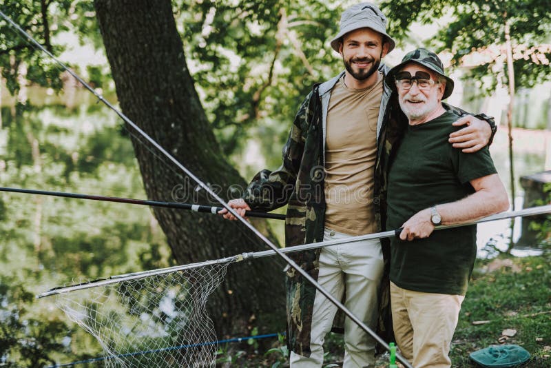 Positive delighted embracing his father while fishing royalty free stock image Positive delighted embracing his father while fishing royalty free stock image