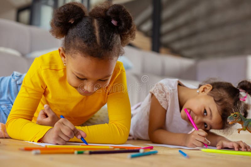 Positive delighted girl drawing picture for her mother