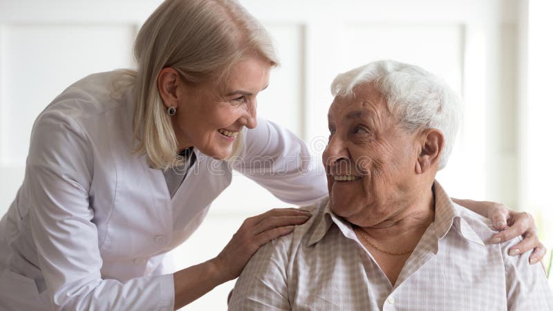 Positive female nurse taking care of senior male patient