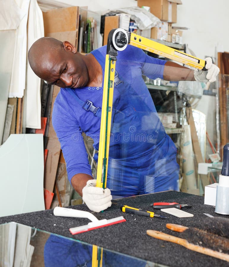 Glass Factory Worker Measuring Glass with Angle Finder Level before