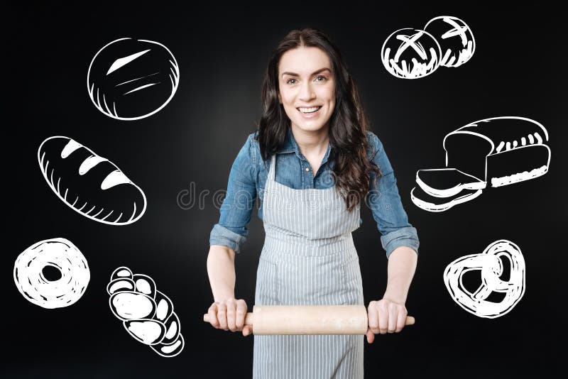 Positive Frau, die ein Nudelholz beim Lernen, Brot zu kochen hält stockbilder Positive Frau, die ein Nudelholz beim Lernen, Brot zu kochen hält stockbilder