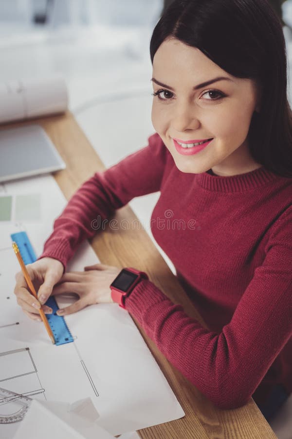 Positive frohe Frau, die zu Ihnen lächelt stockfoto
