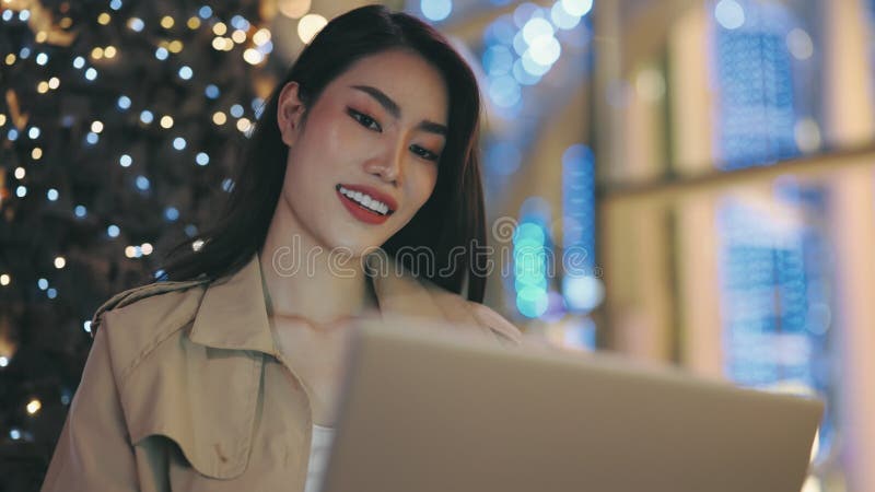 Positive Girl Using Laptop, Chats with Friends While Texting Outside in the Evening.