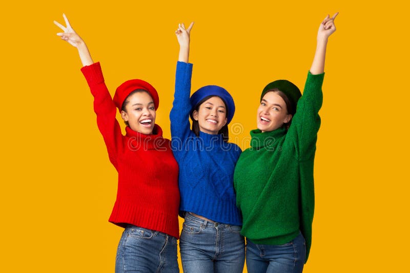 Positive Girls Gesturing V-Sign Smiling Posing Over Yellow Background royalty free stock photos Positive Girls Gesturing V-Sign Smiling Posing Over Yellow Background royalty free stock photos