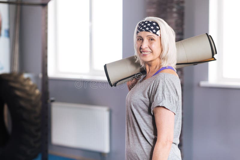 Positive Greisin, die eine Yogamatte hält stockbilder Positive Greisin, die eine Yogamatte hält stockbilder