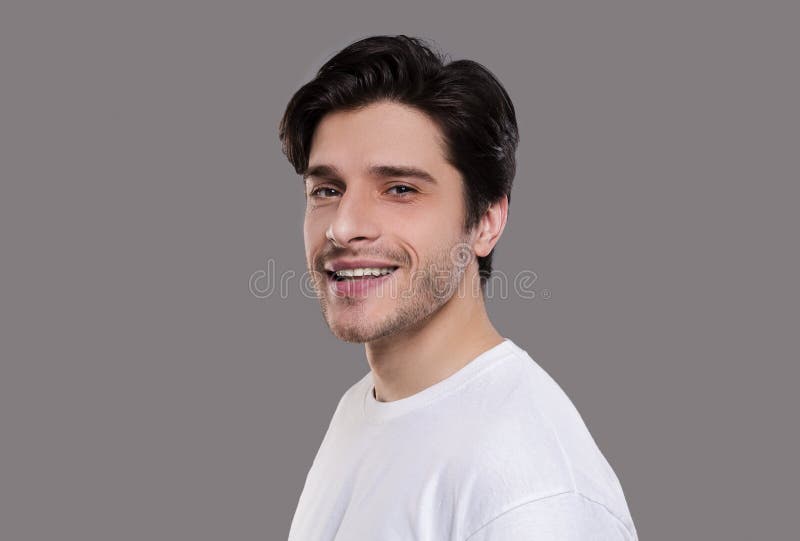 Positive handsome man smiling on grey background royalty free stock image Positive handsome man smiling on grey background royalty free stock image