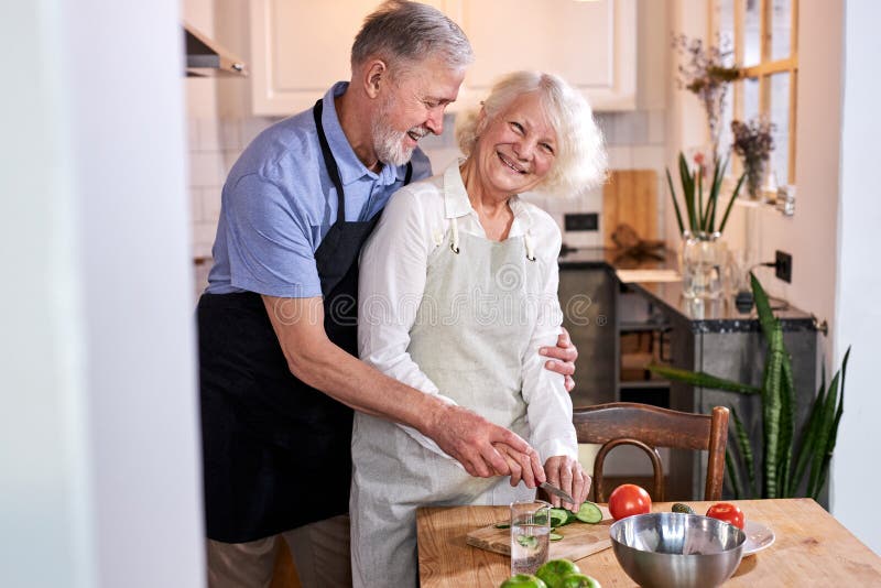 positive mature couple cooking together royalty free stock photos